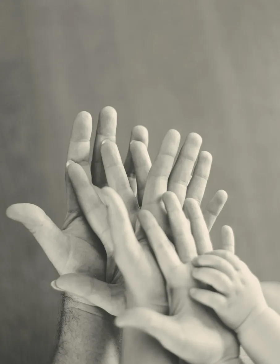 grayscale photo of family's hands